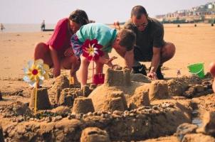 Photograph of a family building sandcastles